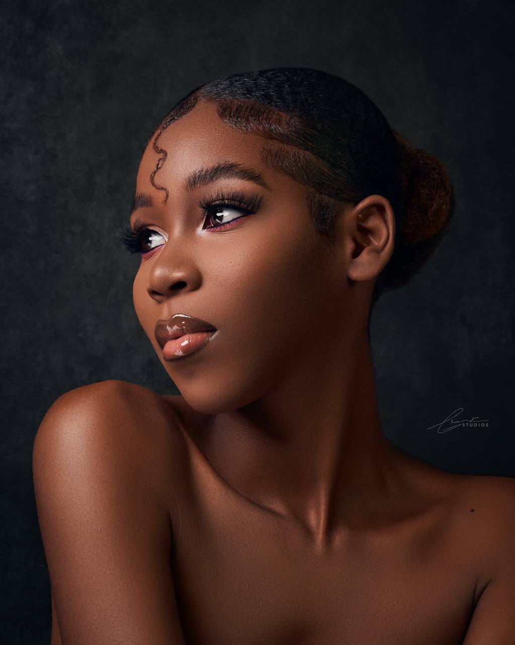 Close portrait study with soft light, clean skin tones, and a dark studio backdrop